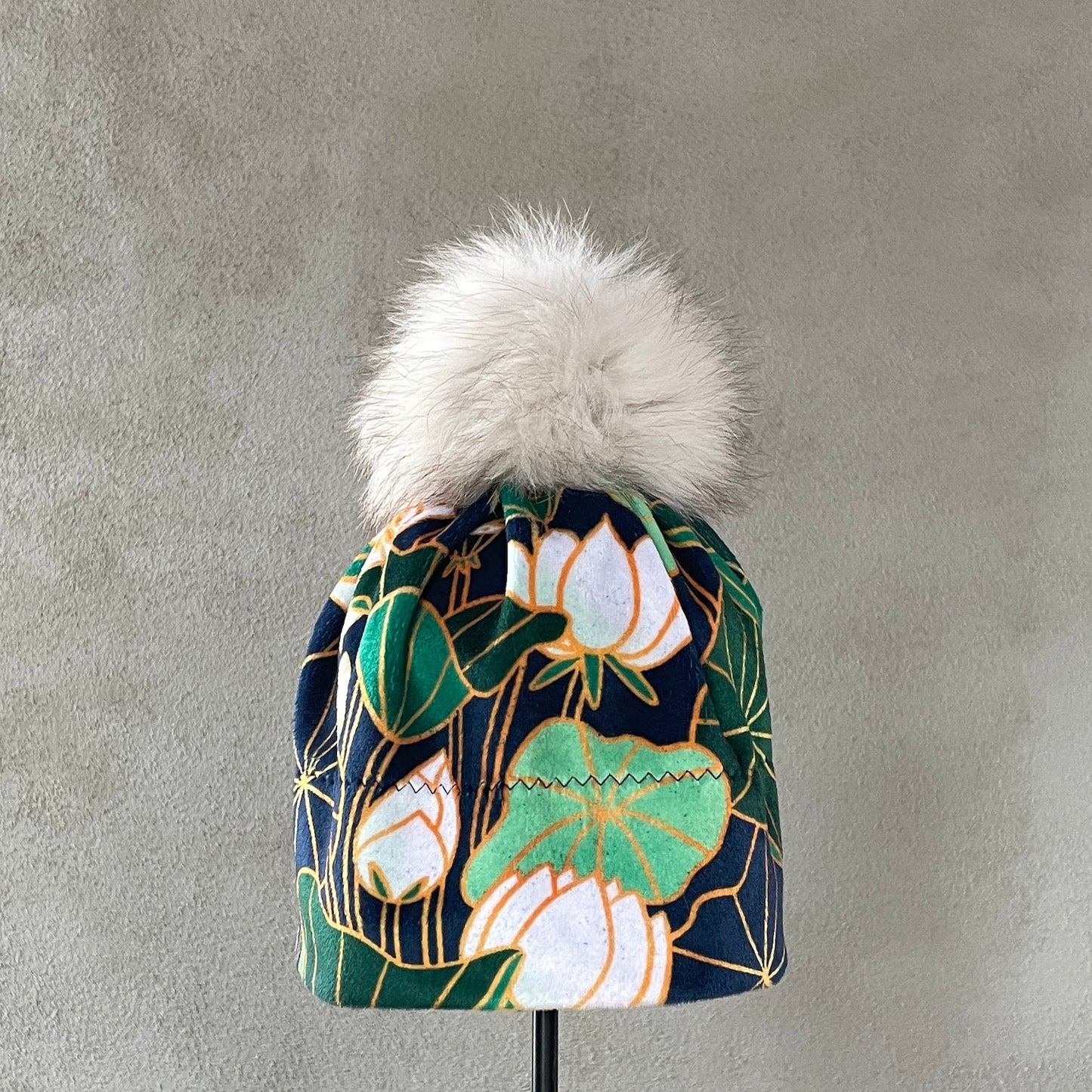 Blå-lue-til-dame-med-hvite-blomster-og-grønne-blader