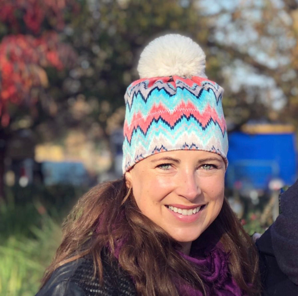 Bilde av dame i en park i London som har lue med duse toner og sikksakkmønster