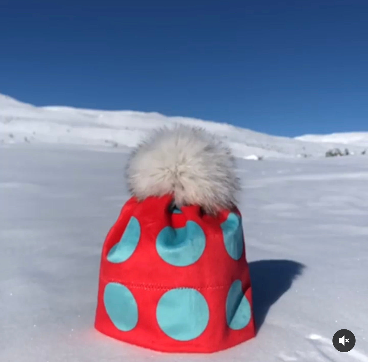 Bilde av rød lue med turkise prikker og pelsdusk.